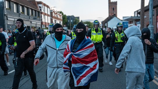 People demonstrate near the Bell Hotel on Sunday in Epping, England.