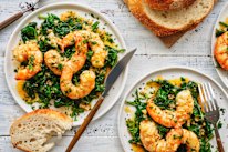 Garlic-butter and white-wine prawns over wilted spinach.