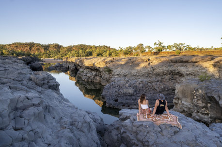 Couple sitting on blanket on the waters edge at Copperfield Gorge.