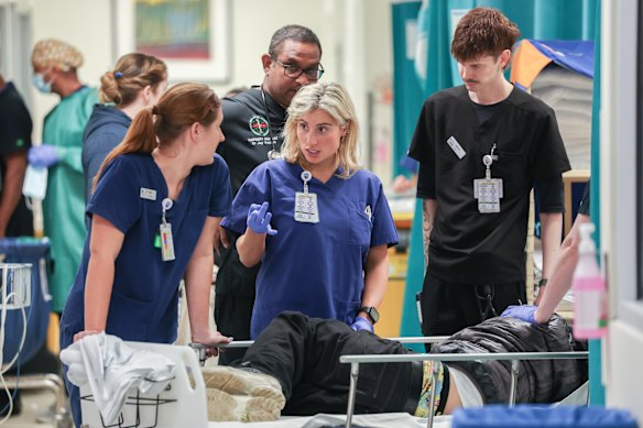 St Vincent’s Hospital nurse Julia Schwarcz (centre) assesses a patient who has been brought into the emergency department.