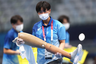 A field of play team member holds a Prosthetic leg before a race on Monday.