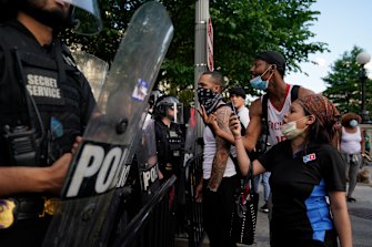 Demonstrators vent to police in riot gear as they protest the death of George Floyd near the White House in Washington on Saturday.