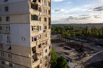 A shattered apartment building towers over a bomb cratered street on May 15, 2022 in Kharkiv.