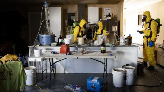 A group of trainees work their way through a mock drug lab.