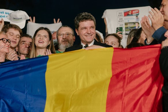 Romanian presidential candidate Nicusor Dan (centre) and supporters after the first exit poll results on Sunday.