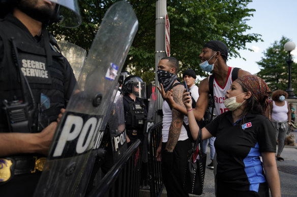 Demonstrators vent to police in riot gear as they protest the death of George Floyd near the White House in Washington on Saturday.