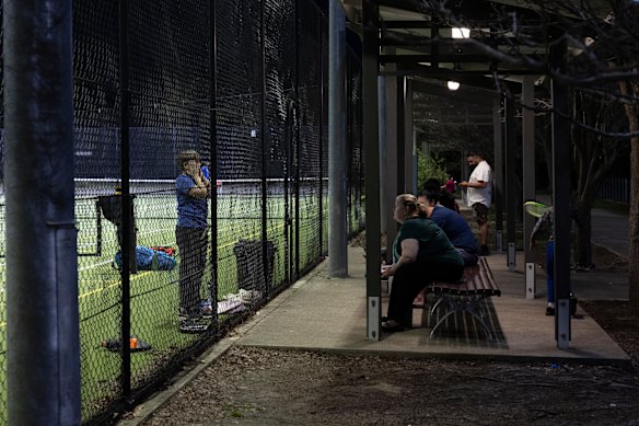 Parents watch their kids’ tennis lessons.