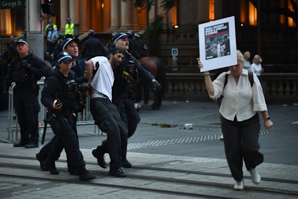 A polícia prende um manifestante na George Street.