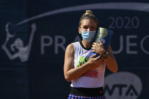 Simona Halep celebrates with the Prague Open trophy after victory in her first tournament since the coronavirus shutdown.