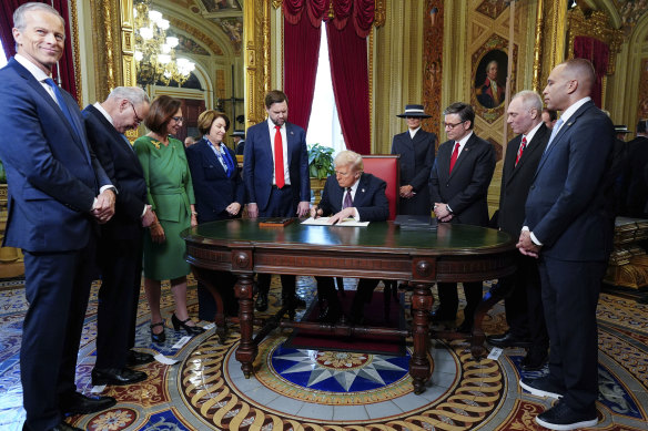 Donald Trump signs documents in the President’s Room at the US Capitol.