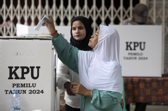 A woman casts her ballot at a polling station during the election in Medan, Indonesia.
