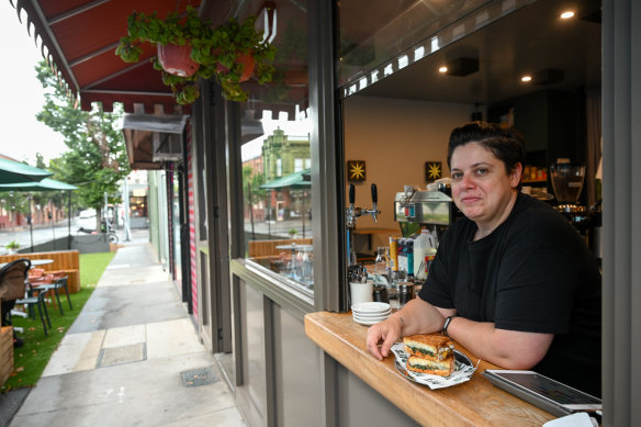Ray’s Sandwich Deli owner Mariella Traina in the window of her store, which is approaching its first year in the suburb.