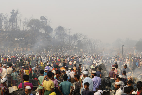 Rohingya refugees stand at the site of Monday’s fire at a refugee camp in Balukhali, southern Bangladesh.