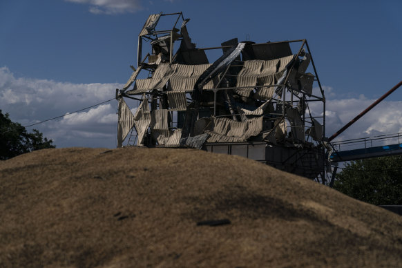 A mangled tower stands behind a mound of grain burned in Russian missile attacks at a grain facility in Pavlivka, Ukraine on July 22.