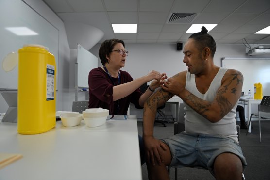 Jayden Poi, right, receives his COVID-19 vaccine from nurse Caryn Gottcent at Woolloomooloo on Thursday.