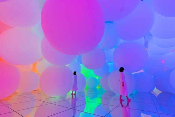 Visitors walk barefoot through a technicolour world of gardens and streams at teamLab.