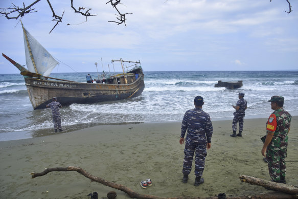 Indonesian military personnel inspect a wooden boat used to carry Rohingya refugees after it landed at Ladong village, in Aceh province, Indonesia.
