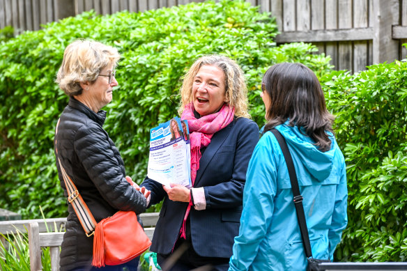 Melissa Lowe (centre) talks to a voter at the Camberwell pre-polling centre.
