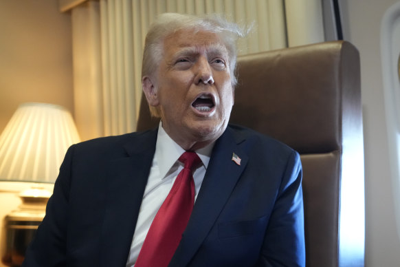 Donald Trump speaks to reporters aboard Air Force One.