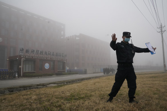 A security official moves journalists away from the Wuhan Institute of Virology after a World Health Organisation team arrived for a field visit in Wuhan in China’s Hubei province on February 3, 2021.