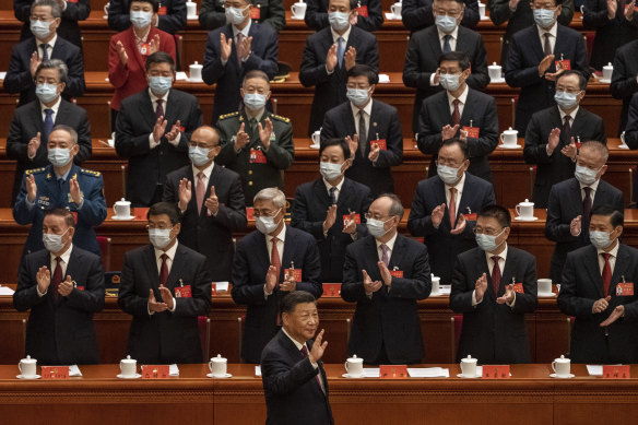 Chinese President Xi Jinping, right, is applauded as he waves to senior members of the government as he arrives to the Opening Ceremony of the 20th National Congress.