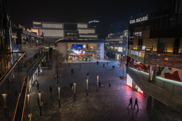 People walk in the courtyard of a shopping mall after local authorities asked restaurants in the area to only serve takeaway food and some stores to close in an effort to prevent the spread of COVID-19 in Chaoyang District on November 18.