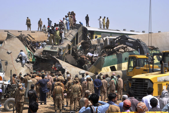 Rescuers search for survivors amid the wreckage of the trains in Ghotki.
