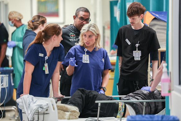 St Vincent’s Hospital nurse Julia Schwarcz (centre) assesses a patient who has been brought into the emergency department. 