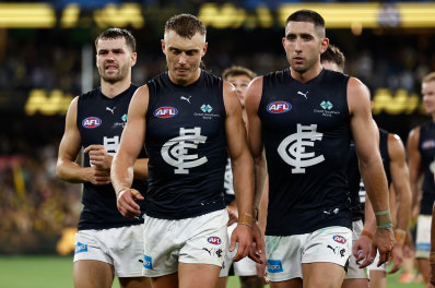 Patrick Cripps and Jacob Weitering lead the Blues from the field after losing to Richmond.