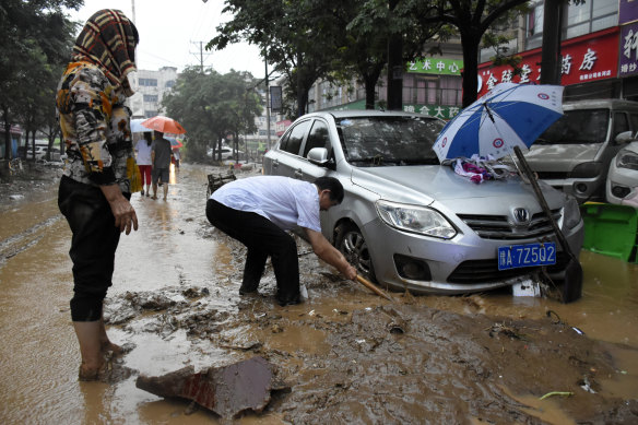 Residents clean up the aftermath of a flood in Mihe Town of Gongyi City, in central China’s Henan province.