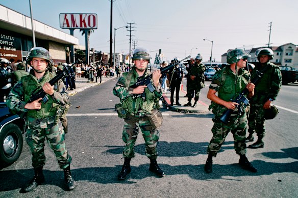 Soldados armados da Guarda Nacional mantêm uma linha no centro-sul de Los Angeles após tumultos em 1992.