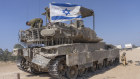 An Israeli soldier attaches an Israeli flag on top of an armoured personnel carriers near Israel’s border with Gaza on Monday.