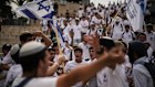 Israelis wave national flags during a march through Jerusalem.