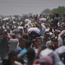 Palestinians carry bags containing food and humanitarian aid packages delivered by the Gaza Humanitarian Foundation in Rafah.