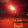 A demonstrator holds up a flare as she stands on a street during a protest calling for a deal to release the hostages held in the Gaza Strip by the Hamas militant group, in Tel Aviv, Israel.