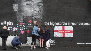Residents put messages of support over racially-charged graffiti on a Marcus Rashford mural in Manchester.