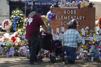 People pay their respects at a memorial outside Robb Elementary School to honour the victims killed in the school shooting in Uvalde, Texas.