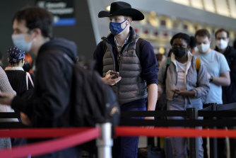 Travellers wait in line while entering a security checkpoint at Logan International Airport, in Boston. 