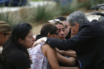 San Antonio başpiskoposu Gustavo Garcia-Siller, Civic Center'ın dışındaki aileleri teselli ediyor. 