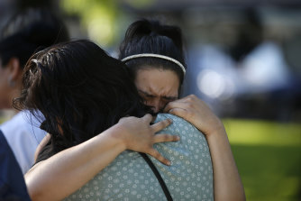 Teksas, Uvalde'de bu haftaki ilkokul saldırısında öldürülen kurbanlar için bir anma alanında bir kadın teselli edildi.