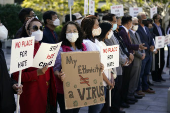 Demonstrators hold signs during a press conference calling to a halt on violence against Asian Americans in Los Angeles on Monday.