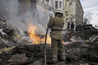 Firefighters attend the scene of a Russian rocket attack in Kharkiv on Monday.
