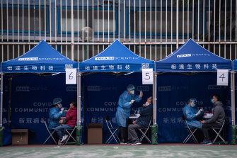 People receive COVID-19 PCR tests at a testing facility in the Tuen Mun area of Hong Kong.