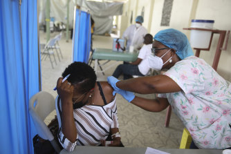 A health worker injects a person with a dose of the Moderna COVID-19 vaccine that was donated through the COVAX initiative at Saint Damien Hospital in Port-au-Prince, Haiti.