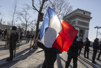  A “Freedom Convoy” supporter carries a French flag at the Arc de Triomphe, in France, where restrictions are slowly being eased.