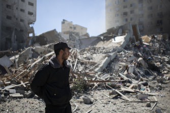 A Palestinian policeman stands in the rubble of a building destroyed by an Israeli airstrike that housed The Associated Press’ offices in Gaza City, Saturday, May 15, 2021. 