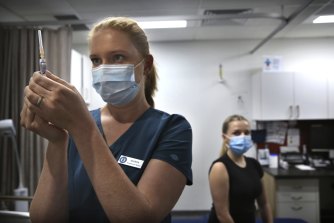 Bir hemşire, Sydney CBD'deki O'Connell Center Tıp Uygulamasında hasta Bronte May-Horswood için bir doz grip aşısı hazırlıyor.