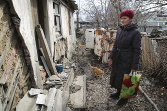 A woman visits her home in the separatist-controlled territory to collect her belongings after a recent shelling near a frontline outside Donetsk, eastern Ukraine, Friday, April 9, 2021. 