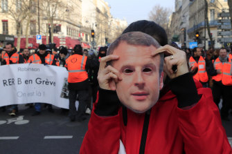 A protester holds a mask of French President Emmanuel Macron during a demonstration in Paris on Friday.