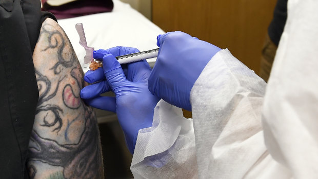 An injection is given as part of a study of a possible COVID-19 vaccine, developed by the National Institutes of Health and Moderna in New York.